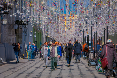 MOSCOW, RUSSIA- APRIL, 24, 2018: Outdoor view of unidentified people walking under a festive Christmas lights on Nikolskaya streets in a sunny dayのeditorial素材