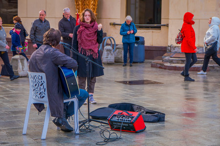 MOSCOW, RUSSIA- APRIL, 24, 2018: Outdoor view of musician playing an electronic guitar in the...