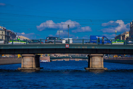 ST. PETERSBURG, RUSSIA, 02 MAY 2018: Outdoor view of unidentified people walking over the Angliyskiy Bridge, with some cars crosing the bridge in St. Petersburgのeditorial素材