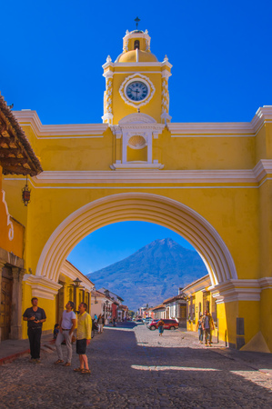 Ciudad de Guatemala, Guatemala, April, 25, 2018: The colorful yellow arch of Antigua city with the active Agua volcano in the background, Guatemalaのeditorial素材