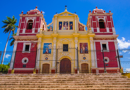 LEON, NICARAGUA, MAY, 16, 2018: Church with yellow facade blending pure neo classical lines and baroque decoration, flanked by two side towers painted fake bricks, Leonのeditorial素材
