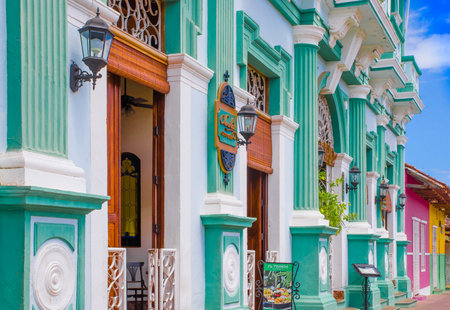 GRANADA, NICARAGUA, MAY, 14, 2018: Outdoor view of facade buildings with turquoise wall and wooden...