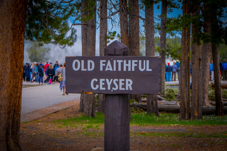 YELLOWSTONE, MONTANA, USA MAY 24, 2018: Close up of informative sign of old faithful geyser written over a wooden structure of the Old Faithful erupting in Yellowstone National Parkのeditorial素材