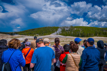 YELLOWSTONE, MONTANA, USA MAY 24, 2018: Tourists watching the Old Faithful erupting in Yellowstone National Parkのeditorial素材