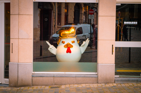 Brussels, Belgium, May, 31, 2018: Outdoor view of gorgeous white chicken sculpture pretending be Donald Trump inside of a building, behind of a glass store in the city of Brusellsのeditorial素材