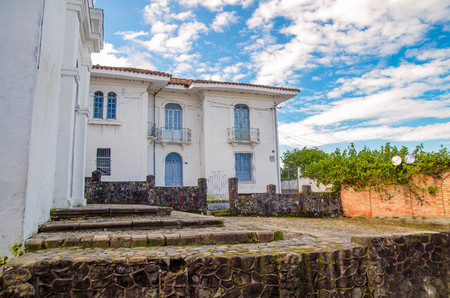 POPAYAN, COLOMBIA - MARCH 31, 2018: Outdoor view of white building with a stoned fence of the town of Popayan, during a sunny day and blue sky in the cityのeditorial素材
