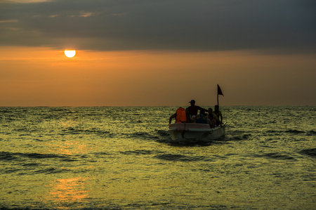 MANABI, ECUADOR, MAY, 29, 2018 Siluetes of unidentified people in a tourist boat during an amazing sunset view in the beach of Cojimiesのeditorial素材