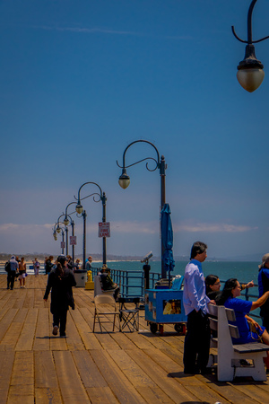 Los Angeles, California, USA, JUNE, 15, 2018: Unidentified people sitting in a wooden bench chair on the bridge overseeing Santa Monica Beach in California USA during sunny dayのeditorial素材