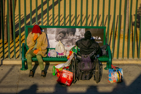 Los Angeles, California, USA, AUGUST, 20, 2018: Outdoor view of homeless couple on a park bench,...