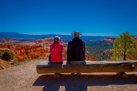 BRYCE CANYON, UTAH, JUNE, 07, 2018: Unidentified people sitting over a log, and enjoying the great spires by erosion in Bryce Canyon National Park, Utahのeditorial素材