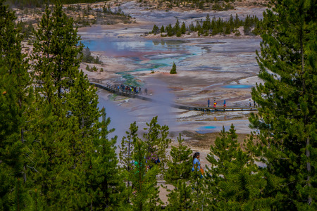YELLOWSTONE, MONTANA, USA JUNE 02, 2018: Above view of people walking in the boardwalk among pools and geysers in Norris Geyser Basin, Yellowstone National Park, Wyomingのeditorial素材