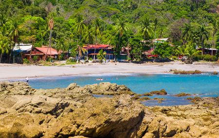 PLAYA MOTEZUMA, COSTA RICA, JUNE, 28, 2018: Unidentified people swimming and enjoying the beautiful blue water in the rocky beach in Playa Montezumaのeditorial素材
