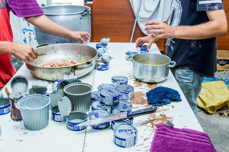 QUITO, ECUADOR, AUGUST 21, 2018: People in kitchen cooking the dinner and open many tuna can, inside of a refuge for Venezuelan people that escaped from their country because economical situationのeditorial素材