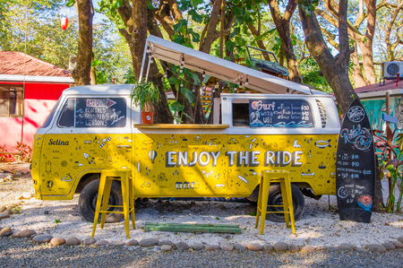 Tamarindo, Costa Rica, June, 26, 2018: Outdoor view of yellow van parked at outside of a building hostal, used to host tourists in Tamarindo beach in a gorgeous sunny dayのeditorial素材