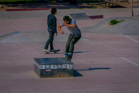 SANTIAGO, CHILE - SEPTEMBER 13, 2018: Outdoor view of two young teenagers skating and umping in a public stoned park located in the city of the Republic in Santiagoのeditorial素材