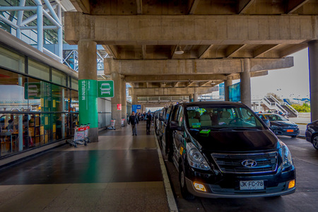 SANTIAGO, CHILE - SEPTEMBER 13, 2018: Outdoor view of many minibuses parked at the enter of the airport Unidentified people walking for the arrival of passengers at the airport in Santiagoのeditorial素材