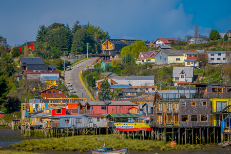 CHILOE, CHILE - SEPTEMBER, 27, 2018: Boat close to a houses on stilts palafitos in Castro, Chiloe Island, Patagoniaのeditorial素材