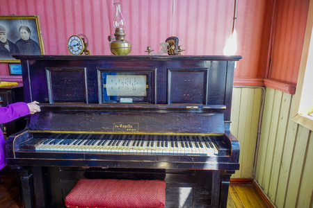 CHONCHI, CHILE, SEPTEMBER, 27, 2018: Indoor view of black piano inside of museum of chonchi filled with furniture and ornaments from the 1920s, donated by families of Chonchi, opened in 1996のeditorial素材