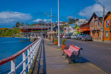 CHILOE, CHILE - SEPTEMBER, 27, 2018: Outdoor view of some cars parked in the street in front of gorgeous chonchi harbour in Chiloe islandm surrounding of beautiful wooden houses in Chileのeditorial素材