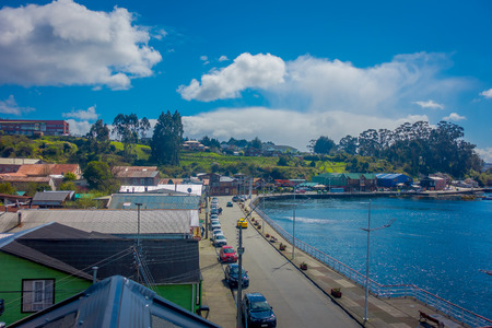 CHILOE, CHILE - SEPTEMBER, 27, 2018: Above view of some cars parked in the street in front of gorgeous chonchi harbour in Chiloe islandm surrounding of beautiful wooden houses in Chileのeditorial素材
