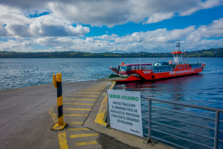 CHILOE, CHILE - SEPTEMBER, 27, 2018: Outdoor view of small red ferry with some cars boarding in the chonchi harbour in Chiloe island Chileのeditorial素材