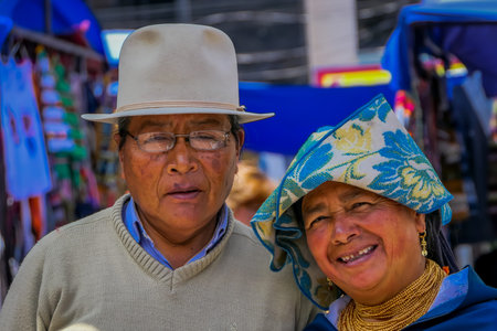 OTAVALO, ECUADOR, NOVEMBER 06, 2018: Portrait of indigenous couple posing for camera and wearing andean traditional clothing in street market in Otavaloのeditorial素材