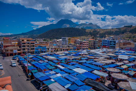 OTAVALO, ECUADOR, NOVEMBER 06, 2018: Above outdoor view of many huts located in the street market in Otavalo with a mountain behind in Otavaloのeditorial素材