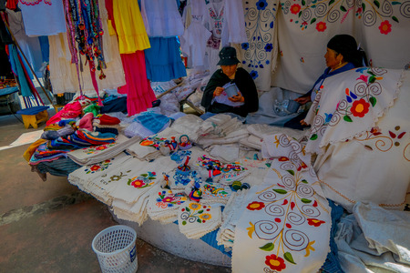 OTAVALO, ECUADOR, NOVEMBER 06, 2018: Unidentified women eating the lunch and selling the typical andean fabrics sold on the handicrafts market of Otavaloのeditorial素材