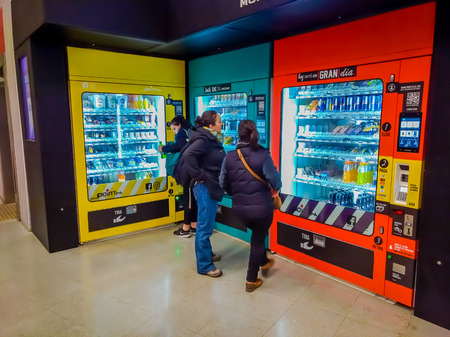 SANTIAGO, CHILE - OCTOBER 09, 2018: Unidentified people in front of a coin machine of juice and snacks located in the Sweeden station line 6 in Metro station in Santiagoのeditorial素材