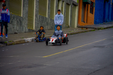 QUITO, ECUADOR - AUGUST 21, 2018: Close up of boy racing a wooden car in an urban road inside of the streets of San Juan in the city of Quitoのeditorial素材
