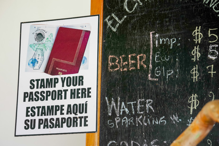 GALAPAGOS, ECUADOR- NOVEMBER, 11 2018: Indoor view of informative sign located in the wall of a building with a description of stamp the passport in the Galapagos islandのeditorial素材
