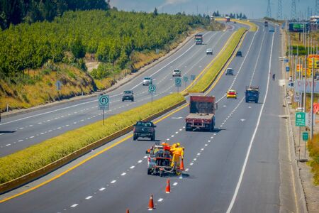 Cotopaxi, ECUADOR - 08 September 2019: Workmen painting lines on road. Road line car painting white lines and central road line marking.のeditorial素材