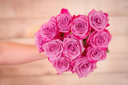 Women hand holding a bouquet of Moody Blues roses variety, studio shot.の写真素材