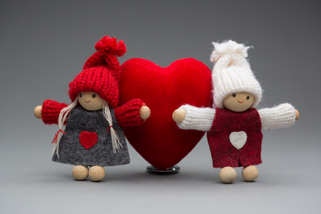 Two dolls in love on Valentines day knitted wear with heart postcardの写真素材