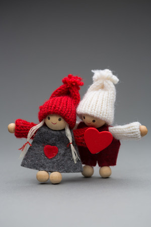 Two dolls in love on Valentines day knitted wear with heart postcardの写真素材