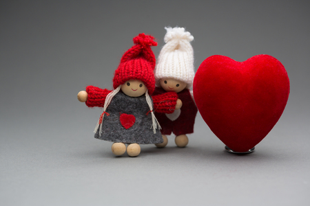 Two dolls in love on Valentines day knitted wear with heart postcardの写真素材