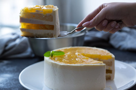 Mango fruit Mousse Cake, decorated with fresh fruits in jelly. Whipped cheese with biscuits.