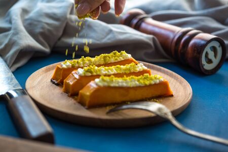 Sweet pumpkin dessert with cream cheese. Healthy tasty eastern food on the plate. sweet dessert with toppingの写真素材
