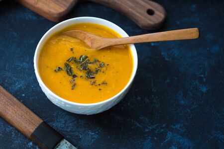 Pumpkin cream soup. Fresh soup with herbs on a background, Autumn concept. Tasty healthy foodの写真素材