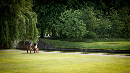 CAMBRIDGE, UK - JUNE 8, 2006: A pair of students relaxing by the River Cam and enjoying each others company in the rural environment of Cambridge University, UK.のeditorial素材