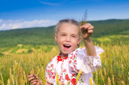 portrait of a girl on a wheat field close up in a landscapeの写真素材