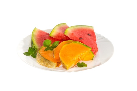 melon and watermelon slices on a white plateの写真素材