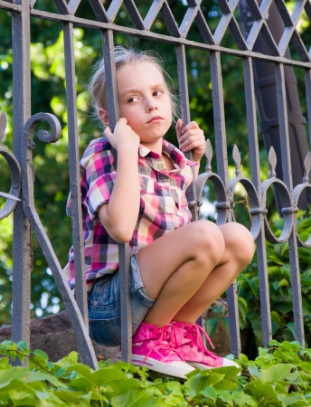  sad girl in the summer near the school fenceの写真素材