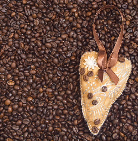 One heart, decorated with ribbon and coffee on coffee beans backgroundの写真素材