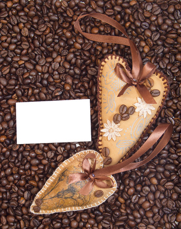 Two hearts, decorated with ribbons and coffee on a background coffee grainsの写真素材