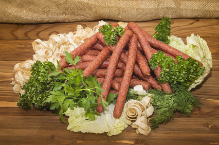 Hunting sausages with herbs on wooden backgroundの写真素材