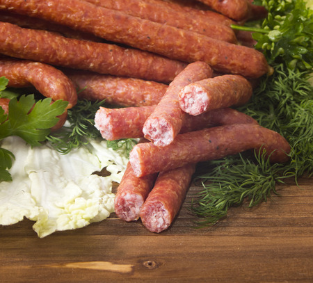 Hunting sausages with herbs on wooden backgroundの写真素材