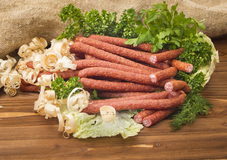 Hunting sausages with herbs on wooden backgroundの写真素材