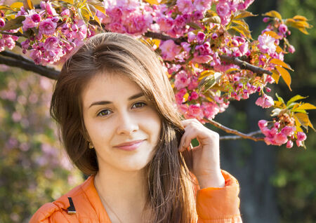 portrait of  happy, beautiful girl in the flowers of sakura の写真素材