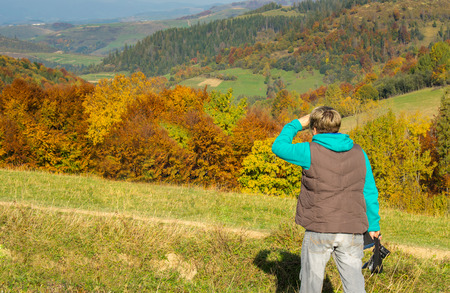 Woman  photographer in the mountains in autumnの写真素材